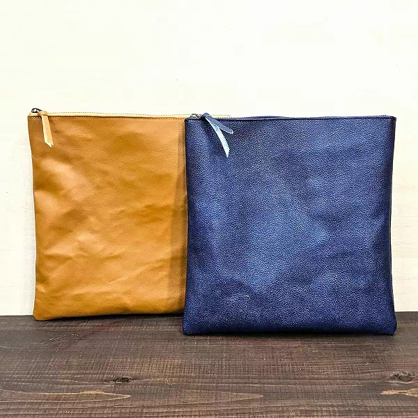 オーダーメイドのプレゼントやギフトに植物タンニン鞣し革と黒桟革の藍染でジップポーチ、クラッチバッグをお客様仕様にオーダー製作